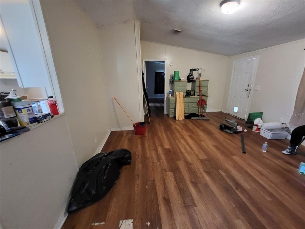 An interior view of a room with wood-look flooring, light walls, and a doorway — 36639 KEEUKA ROAD, ZEPHYRHILLS, FL