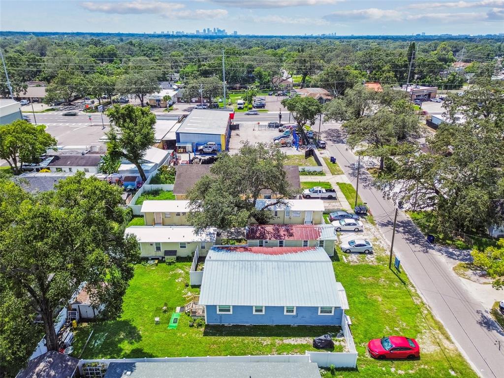 An aerial view shows a blue house with a metal roof and surrounding residential properties — 8413 N HAMNER AVENUE, TAMPA, FL