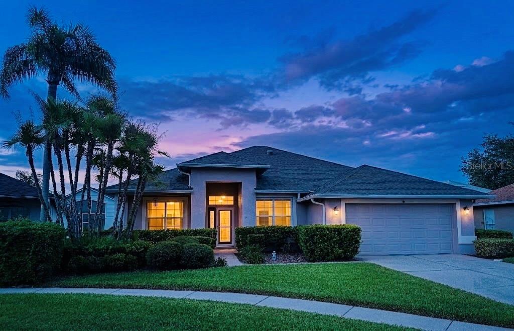 A single-story suburban house with a tan exterior, a two-car garage, and palm trees — 5306 WATERLEAF COURT, VALRICO, FL