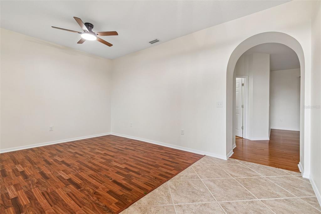 A single-story suburban house with a two-car garage and palm trees at dusk — 5306 WATERLEAF COURT, VALRICO, FL
