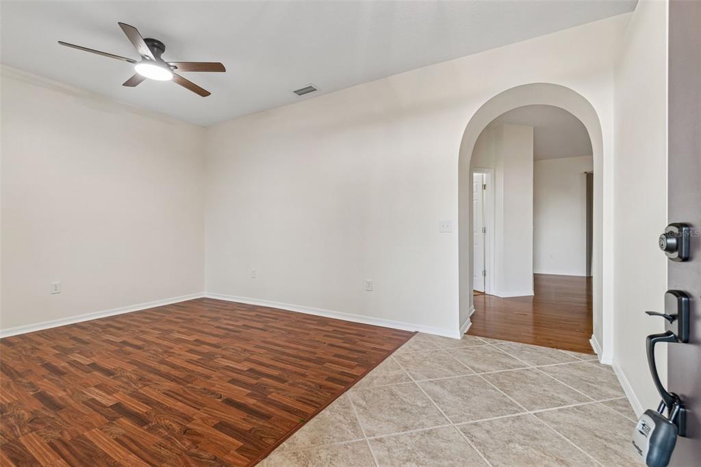 An entryway with tile flooring transitions into a living area with wood-look floors and ceiling fan — 5306 WATERLEAF COURT, VALRICO, FL