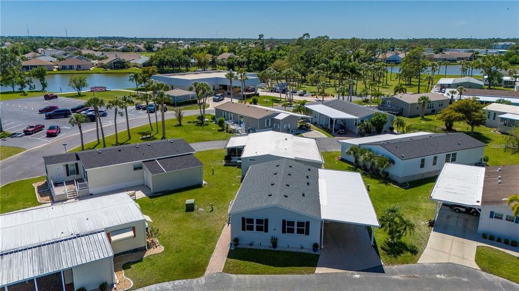 An aerial view shows several manufactured homes with carports and driveways in a residential community — 1000 KINGS HIGHWAY UNIT 133, PUNTA GORDA, FL