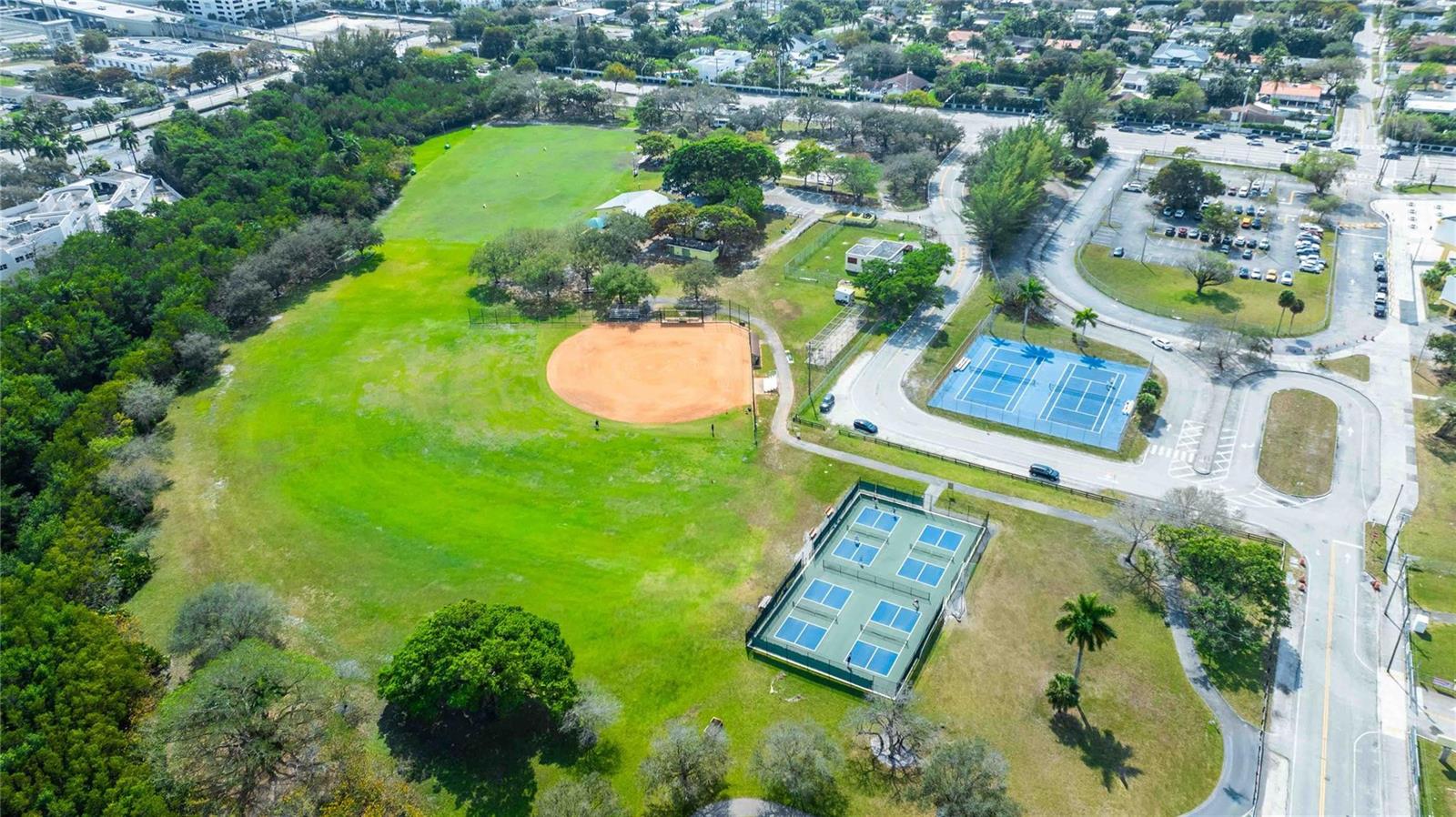 An aerial view shows a park with a baseball field, tennis courts, and parking lots — 2515 NE 207th Street, Miami FL 33180, MIAMI, FL