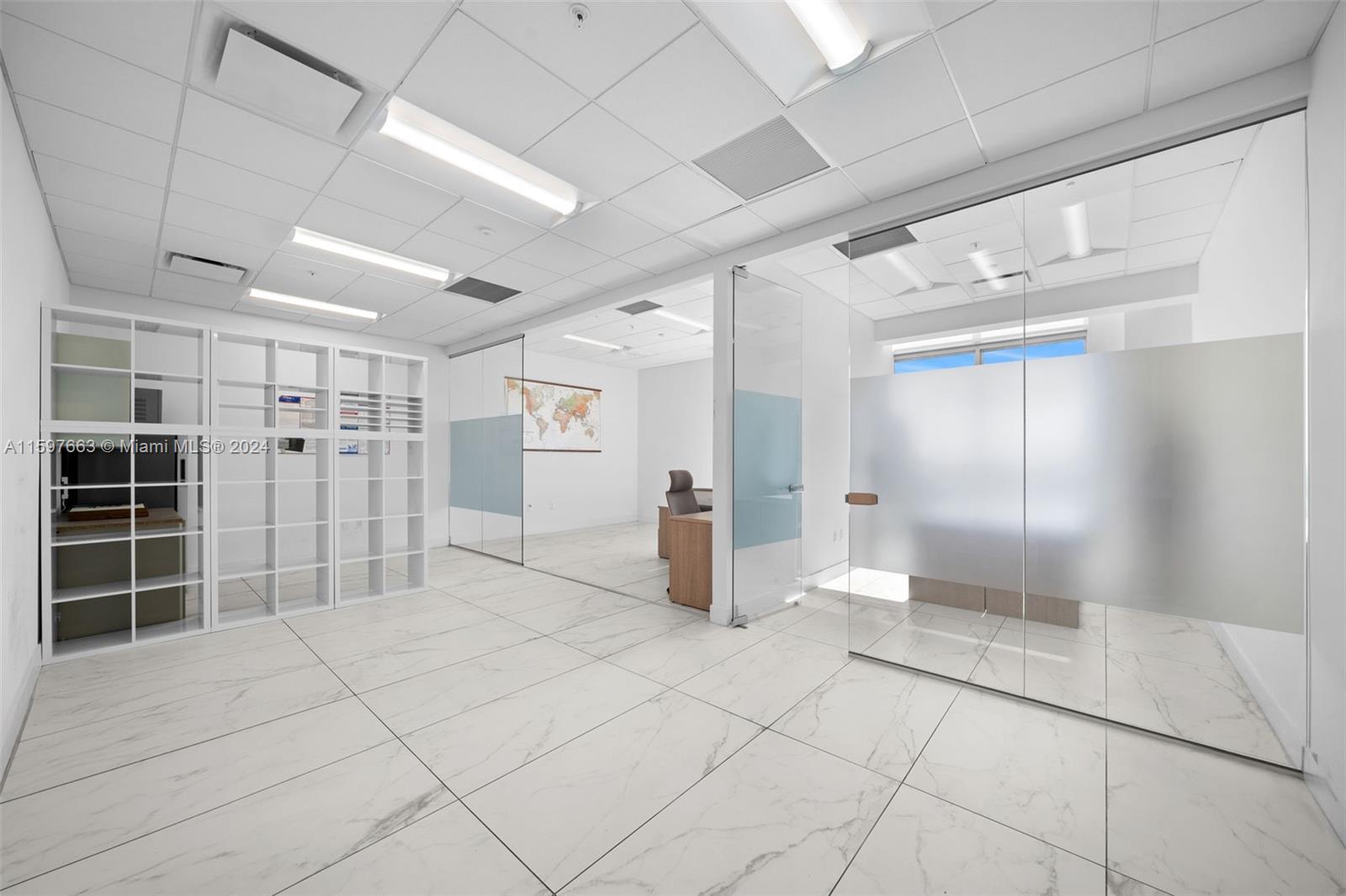 An office space features white marble-look tile floors, glass partitions, and white shelving units — 800 SE 4th Ave # 817, Hallandale Beach FL 33009, HALLANDALE BEACH, FL