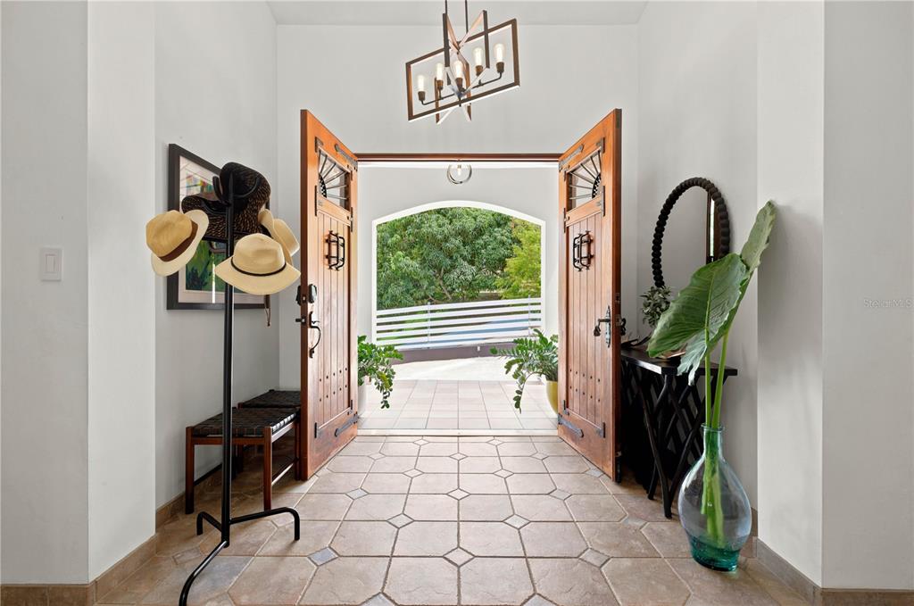 An entryway with tile flooring opens through double wooden doors to an outdoor patio area — Lot-7 MAMEYES I, HACIENDA PANORAMA, LUQUILLO, PR
