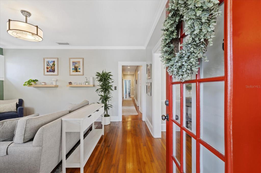 A living room features hardwood floors, a white console table, and a red front door — 3410 W SANTIAGO STREET, TAMPA, FL