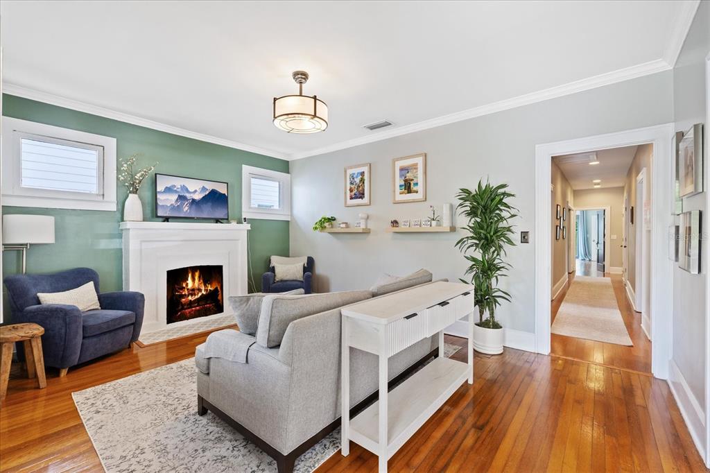 A living room features a fireplace, hardwood floors, a sofa, and a green accent wall — 3410 W SANTIAGO STREET, TAMPA, FL