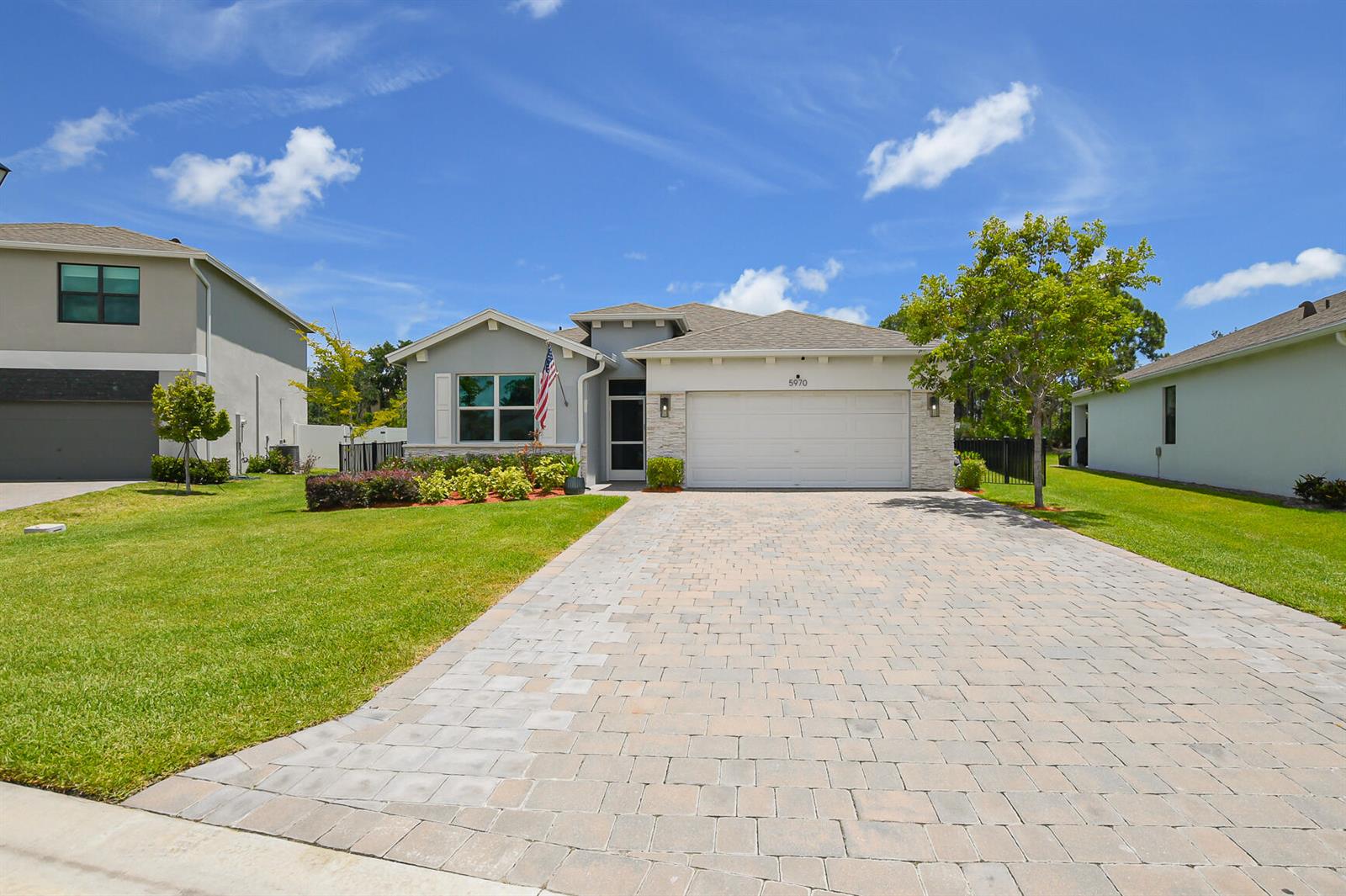 A single-story house with a paved driveway, light gray siding, and a two-car garage — 5970 SE Skyblue Circle, Stuart FL 34997, STUART, FL