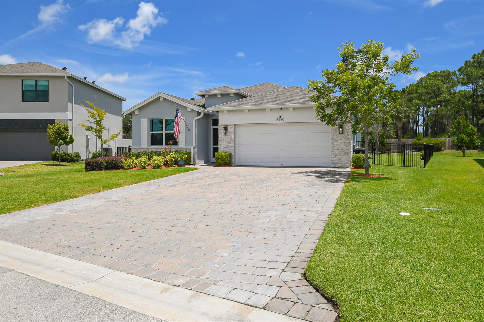 A single-story house with a paved driveway, stone accents, and a two-car garage — 5970 SE Skyblue Circle, Stuart FL 34997, STUART, FL