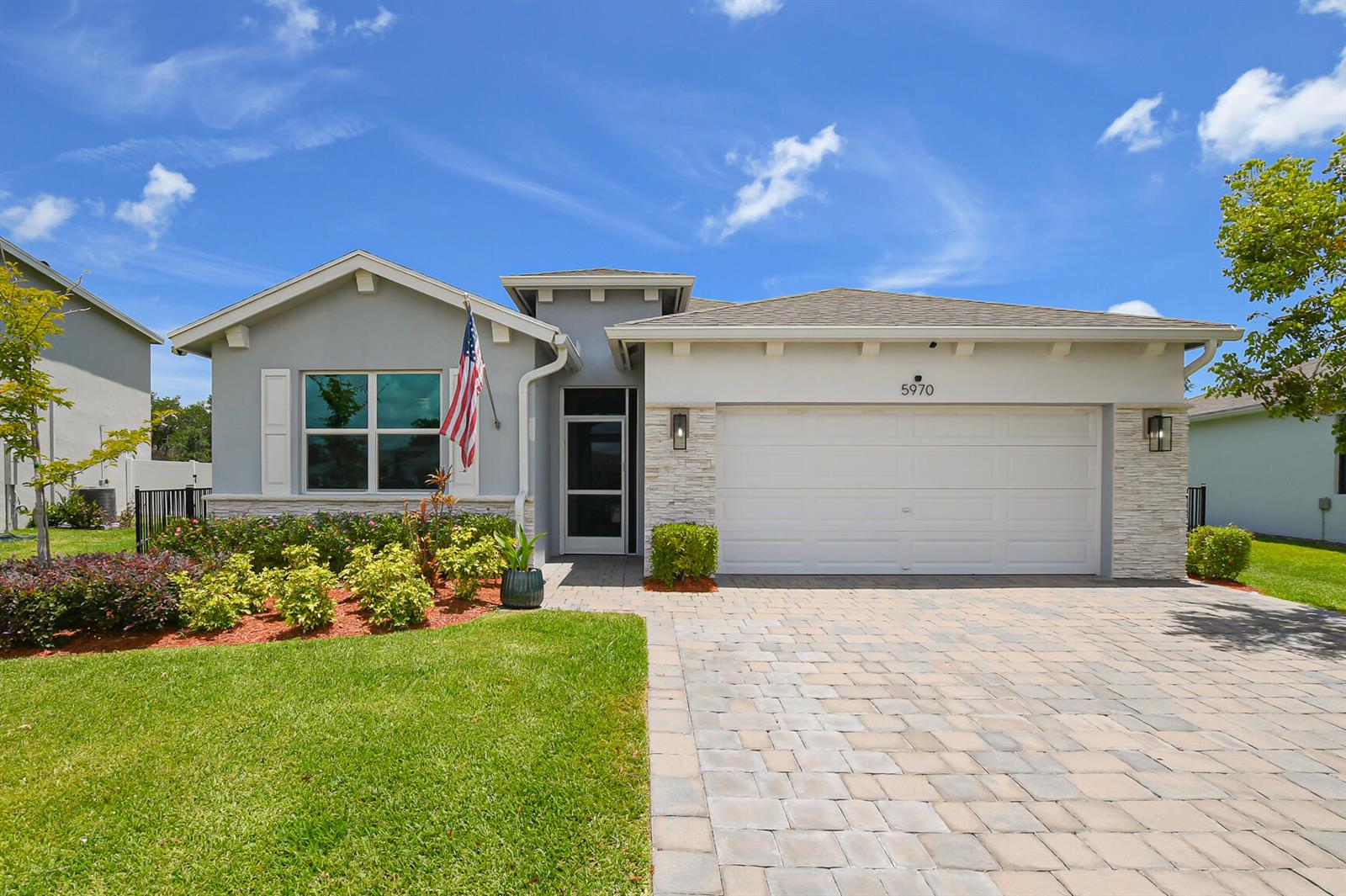 A single-story house with a paved driveway, stone accents, and a front-facing garage — 5970 SE Skyblue Circle, Stuart FL 34997, STUART, FL
