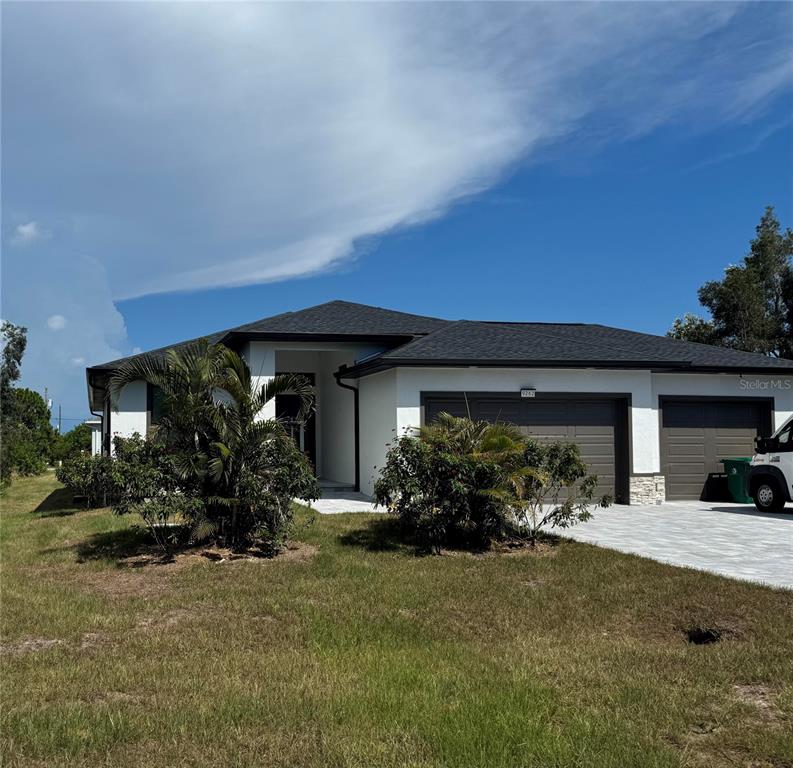 A single-story house with a white exterior, dark roof, and two garage doors — 9262 GENESEE STREET, PORT CHARLOTTE, FL