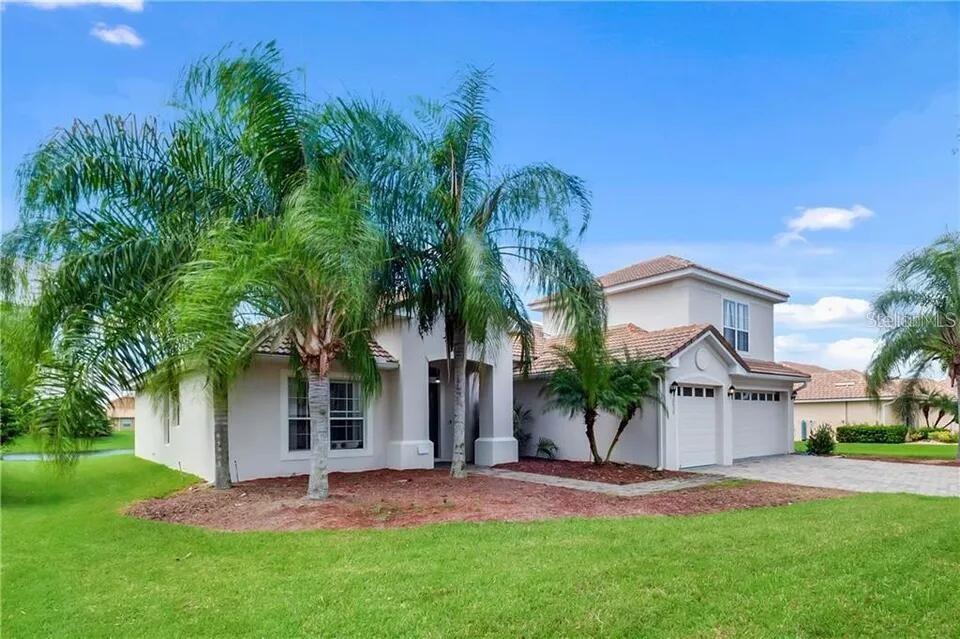 A two-story stucco house with a tile roof, palm trees, and a paved driveway — 2630 CAPTAINS COURT, KISSIMMEE, FL
