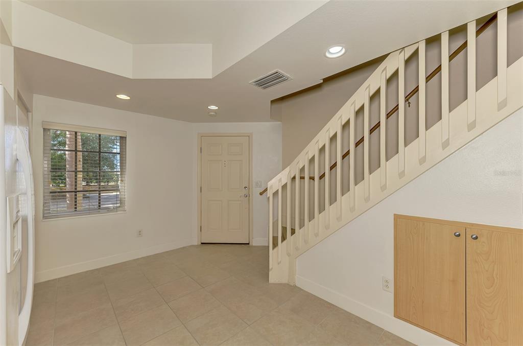 An entryway with tile flooring, a staircase with a wooden railing, and a front door — 1246 RIO DE JANEIRO AVENUE UNIT 510, PUNTA GORDA, FL