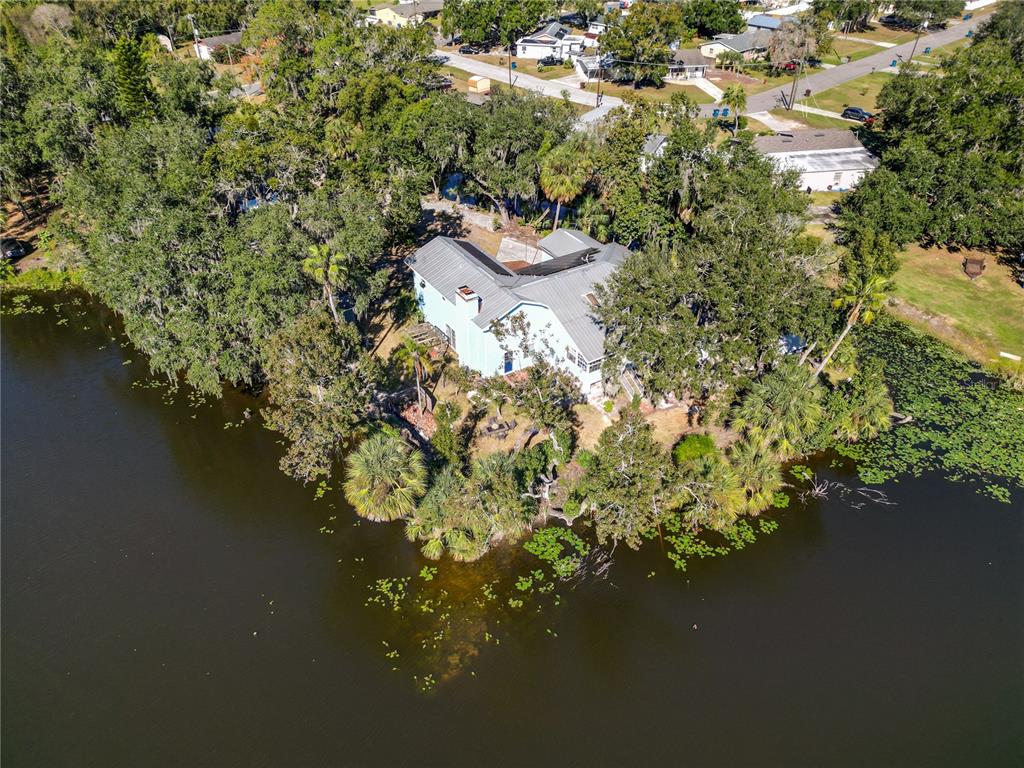 An aerial view shows a concrete driveway leading to a house and a detached garage — 109 NE 4TH AVENUE, MULBERRY, FL