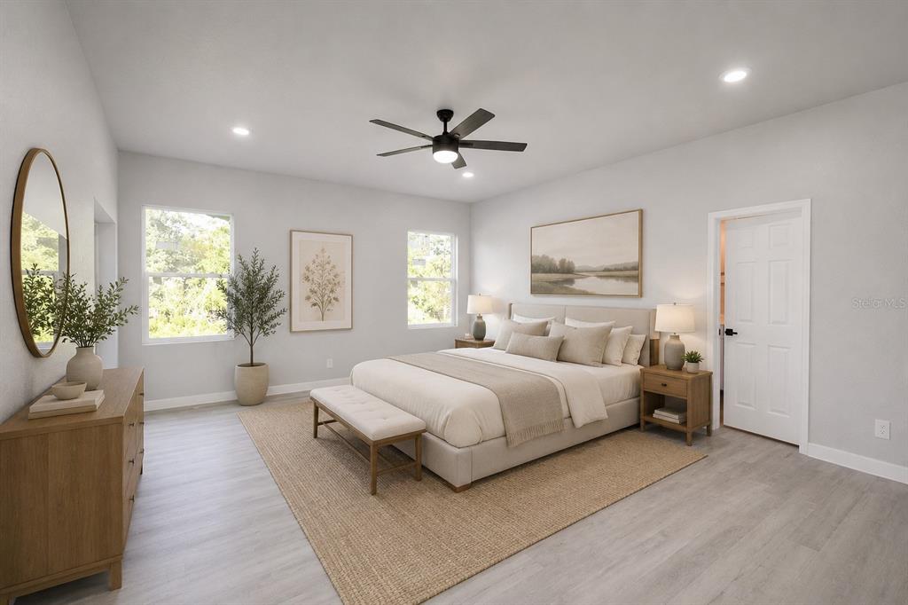 This bedroom features a bed, a dresser, a ceiling fan, and light-colored wood flooring — 4608 CORTEZ BOULEVARD, SEBRING, FL