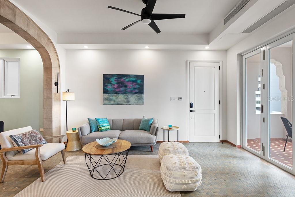 A living room features a grey sofa, a round coffee table, and a ceiling fan — 1506 ASHFORD UNIT 402, SAN JUAN, PR
