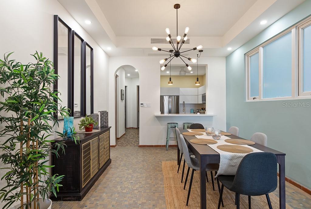 A dining room features a dark wood table, modern chandelier, and a sideboard with mirrors — 1506 ASHFORD UNIT 402, SAN JUAN, PR
