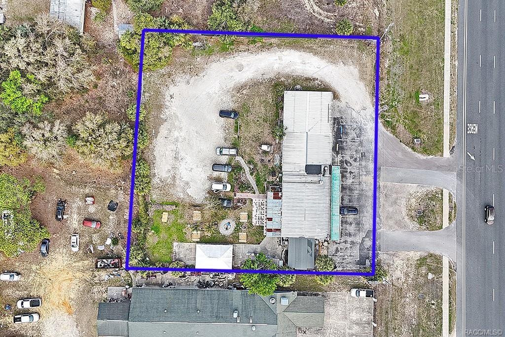 An aerial view shows a commercial building on a lot with a gravel parking area — 4828 S SUNCOAST BOULEVARD, HOMOSASSA, FL