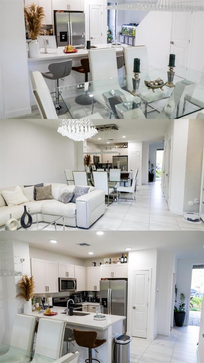 A modern open-concept kitchen and dining area features white cabinetry, stainless appliances, and tile flooring — 148 SE 5th Court, Deerfield Beach FL 33441, DEERFIELD BEACH, FL