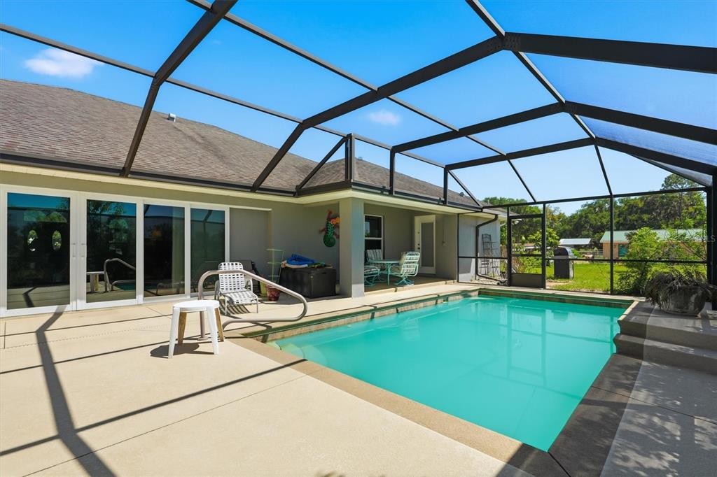 A single-story house with a gray exterior, stone accents, and a large circular concrete driveway — 12764 COUNTY ROAD 223, OXFORD, FL