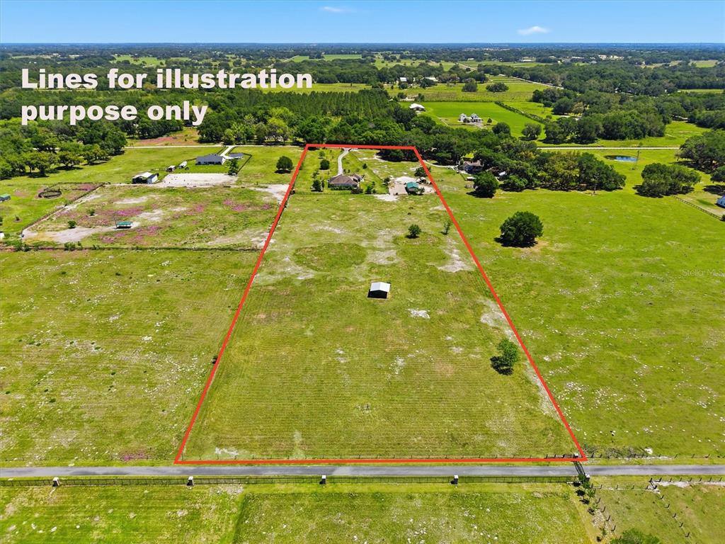 An aerial view of a single-story house with a palm tree and circular driveway — 12764 COUNTY ROAD 223, OXFORD, FL