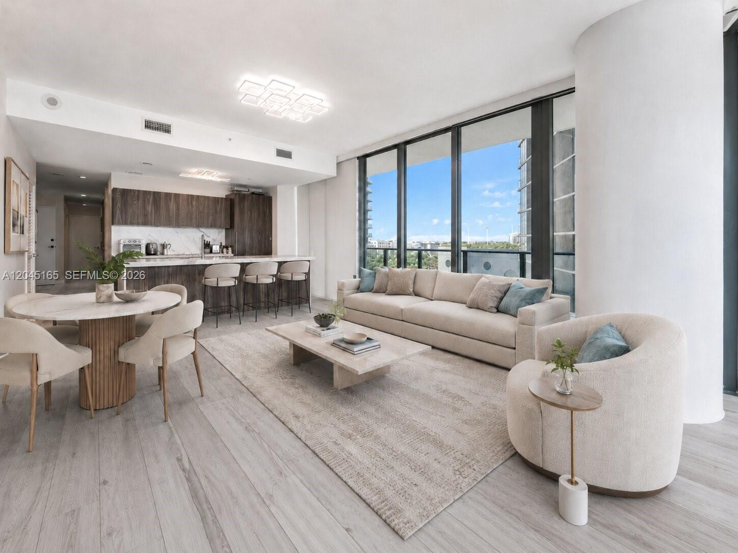 A modern open-concept living room and kitchen feature light wood floors and floor-to-ceiling windows — 480 NE 31st St # 907, Miami FL 33137, MIAMI, FL