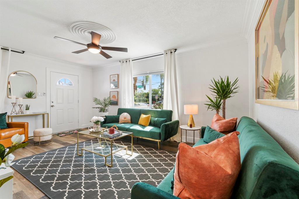 A living room features two green velvet sofas, a glass coffee table, and a ceiling fan — 2402 W CYPRESS STREET, TAMPA, FL