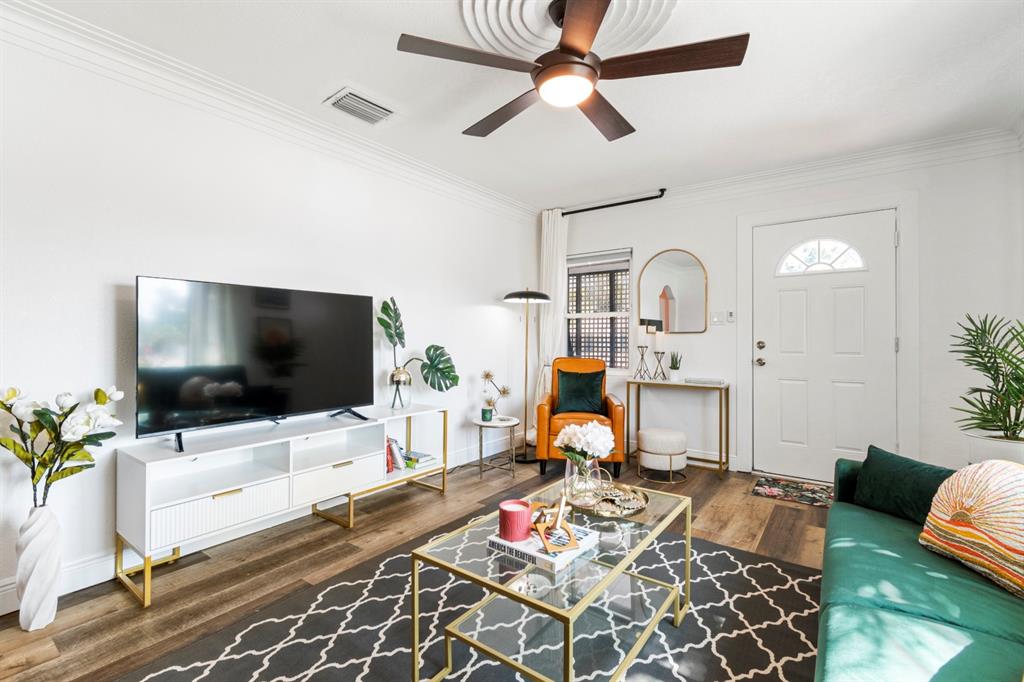 A living room features a green sofa, a glass coffee table, and a white media console — 2402 W CYPRESS STREET, TAMPA, FL