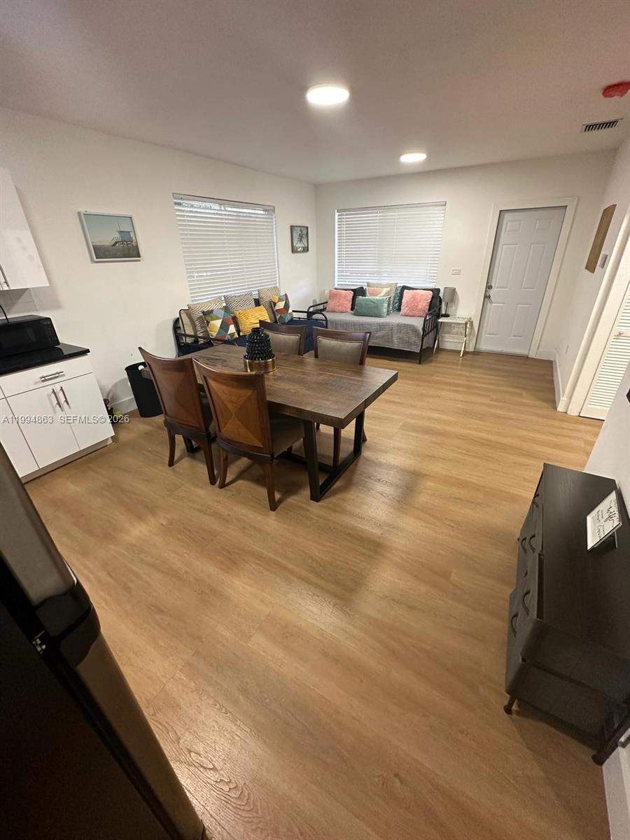 A dining area features a wooden table with chairs and a daybed against the wall — 7460 NW 17th Ave, Miami FL 33147, MIAMI, FL