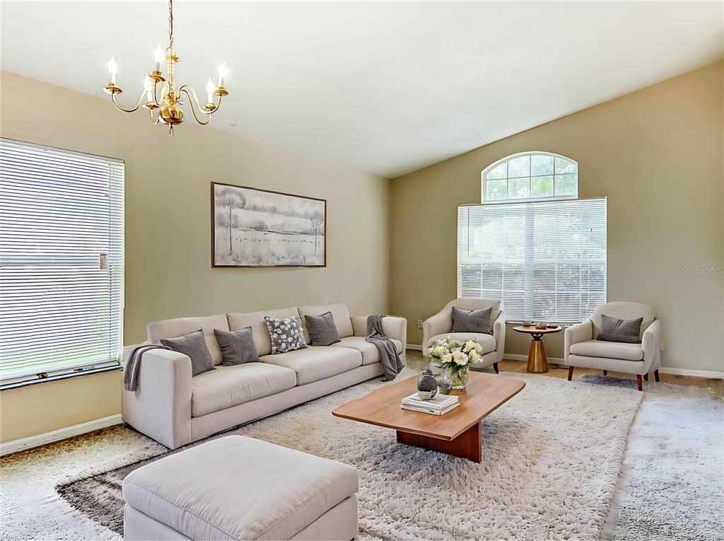 A living room features a beige sofa, two armchairs, a wooden coffee table, and chandelier — 5373 TORTUGA DRIVE, ORLANDO, FL