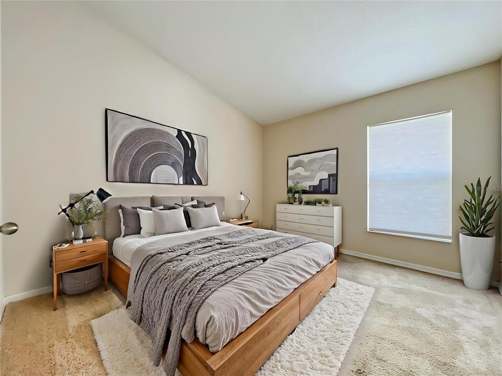 A bedroom features a wooden platform bed, a dresser, wall art, and a large window — 5373 TORTUGA DRIVE, ORLANDO, FL