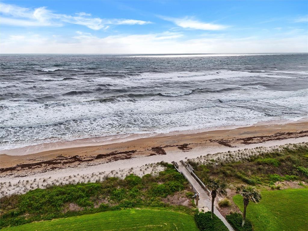 An elevated view of a sandy beach with a wooden boardwalk leading to the ocean — 800 CINNAMON BEACH WAY UNIT 742, PALM COAST, FL