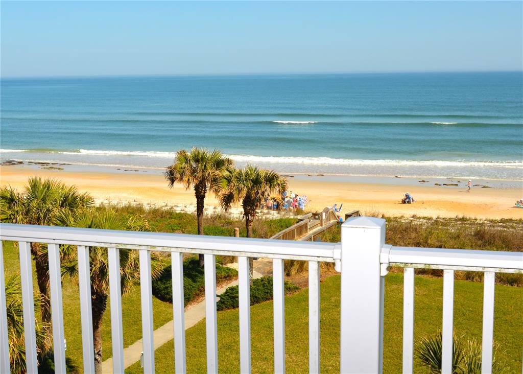 A view of a sandy beach and the ocean from a white balcony railing — 800 CINNAMON BEACH WAY UNIT 742, PALM COAST, FL