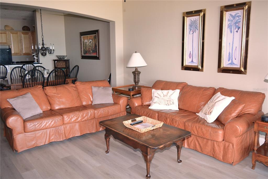 A living room features two tan leather sofas, a wooden coffee table, and wall art — 800 CINNAMON BEACH WAY UNIT 742, PALM COAST, FL