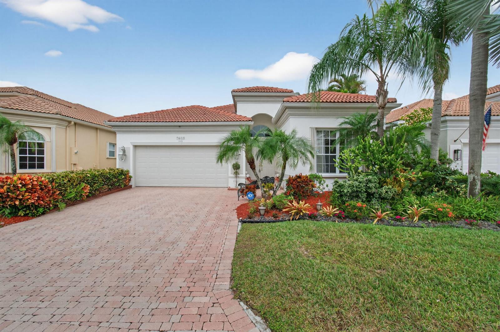 A single-story house with a white stucco facade, red tile roof, and brick paver driveway — 7035 Vivaldi Lane, Delray Beach FL 33446, DELRAY BEACH, FL