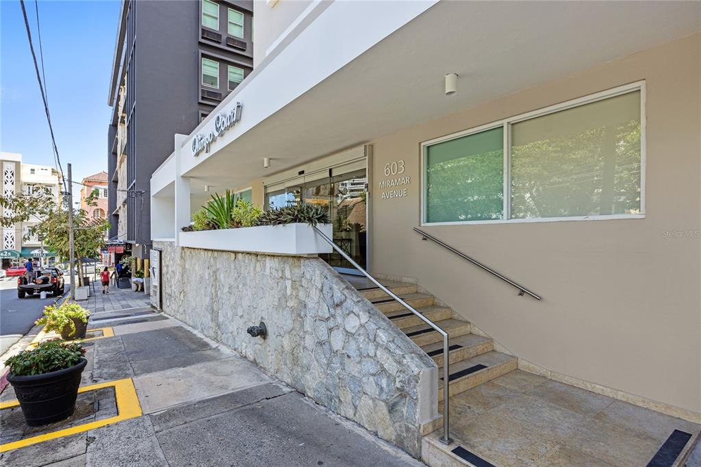 The exterior of a building features a stone-clad base, a staircase, and a glass entrance — 603 MIRAMAR AVENUE UNIT 7, SAN JUAN, PR