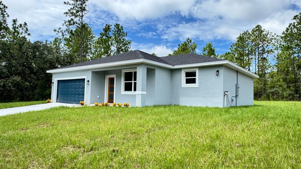 A light blue single-story house with a dark roof, garage, and front entrance — 9278 N SATINWOOD TERRACE, CITRUS SPRINGS, FL