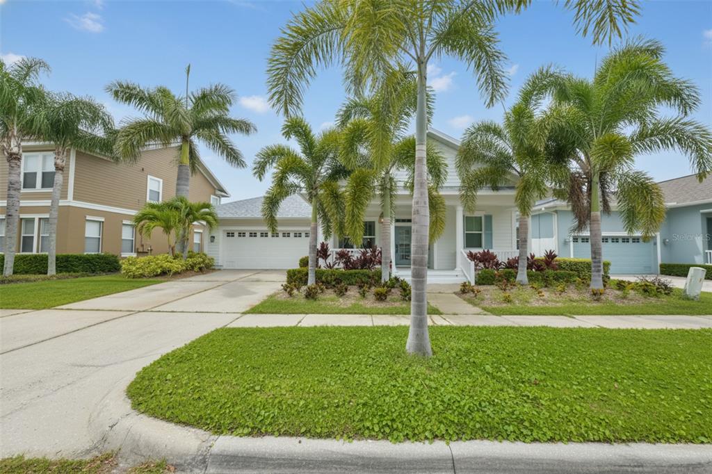 A single-story house with a white exterior, a two-car garage, and several palm trees — 404 ISLEBAY DRIVE, APOLLO BEACH, FL