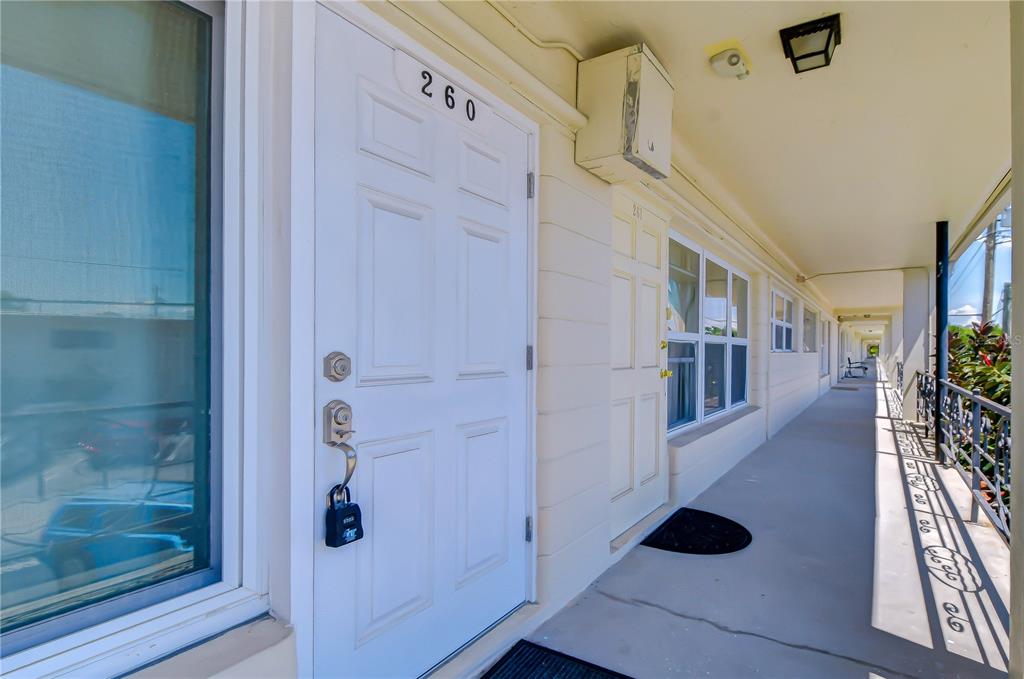 A white door with the number 260 is located on an outdoor apartment building walkway — 4022 57TH STREET N UNIT 260, KENNETH CITY, FL
