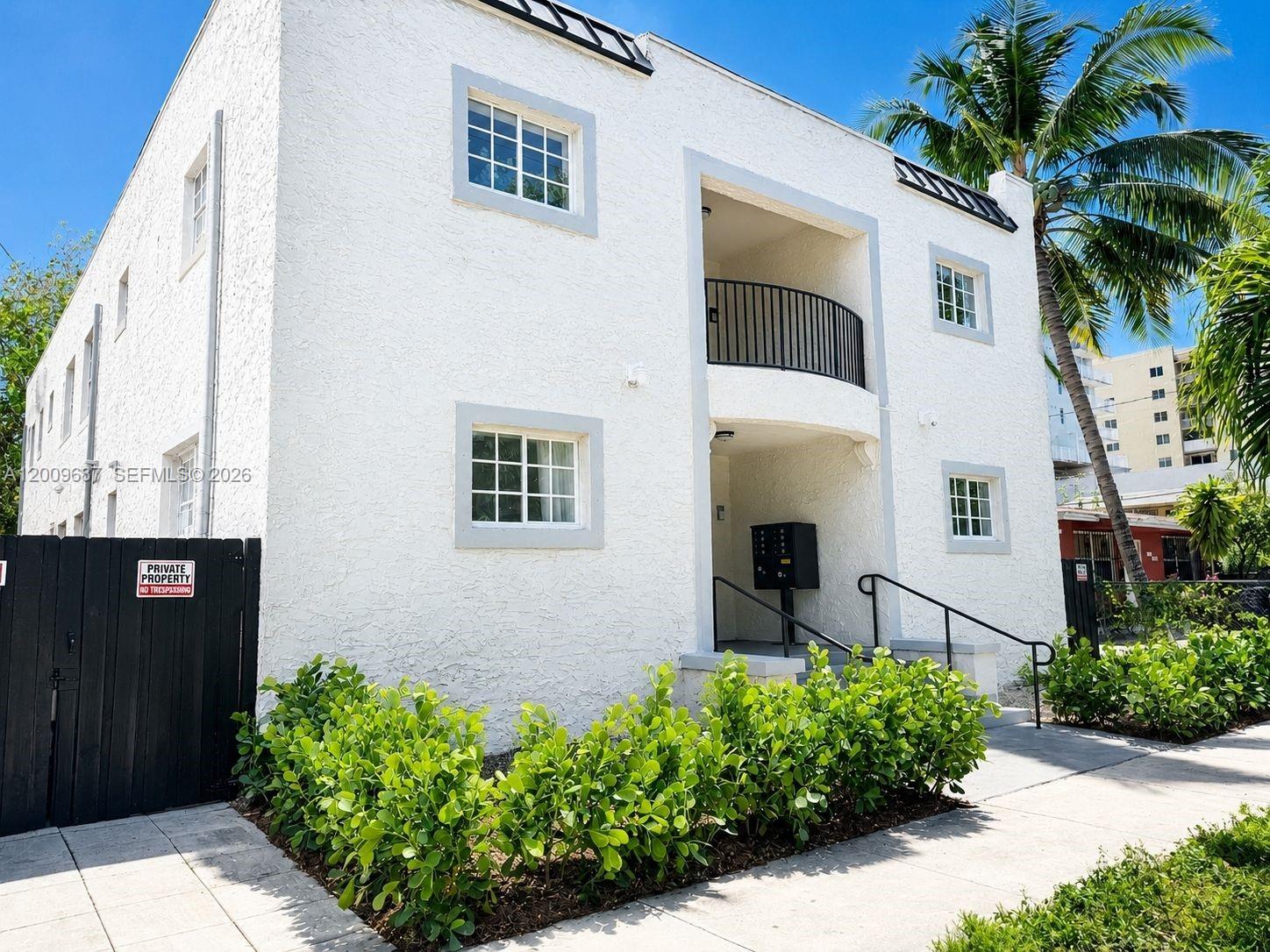 A two-story white stucco apartment building with a black metal balcony and a front entrance — 1132 NW 3rd St, Miami FL 33128, MIAMI, FL