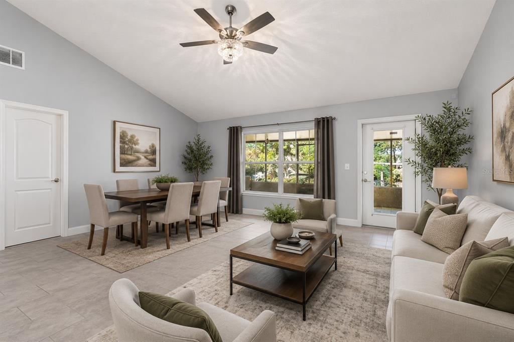 A bright open-concept living and dining area with light gray walls and tile flooring — 60 ANDORA COURT, KISSIMMEE, FL