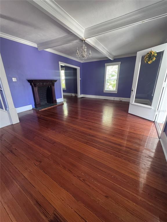A living room features purple walls, hardwood floors, a fireplace, and a white-framed doorway — 12 WEST ORANGE, TARPON SPRINGS, FL