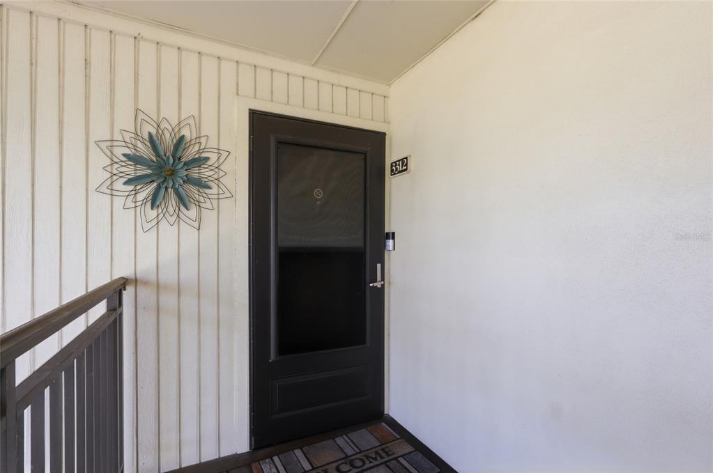A black storm door with the number 3312 is mounted on a white exterior wall — 29130 BAY HOLLOW DRIVE UNIT 3312, WESLEY CHAPEL, FL