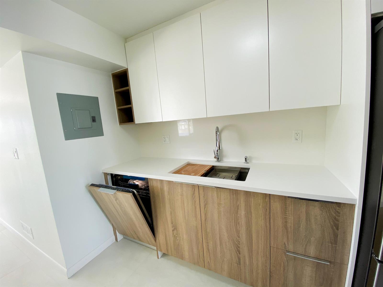 A modern kitchen features white upper cabinets, wood-grain lower cabinets, a sink, and a dishwasher — 2755 NE 28th Avenue # C1, Lighthouse Point FL 33064, LIGHTHOUSE POINT, FL