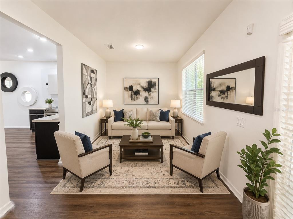 A living room features a beige sofa, two armchairs, a coffee table, and abstract wall art — 12210 LANGSTAFF DRIVE, WINDERMERE, FL