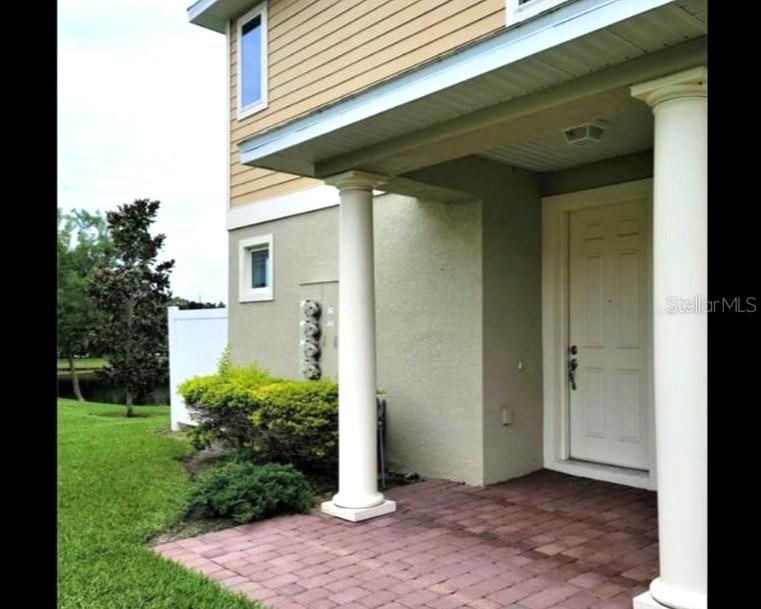 A covered brick entryway features two white columns leading to a front door — 3603 SANCTUARY DRIVE, ST CLOUD, FL