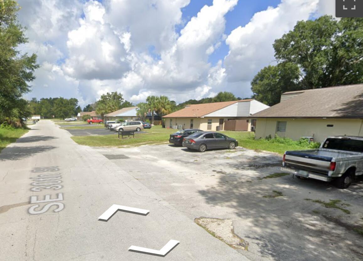 A view of a paved parking lot in front of single-story residential apartment buildings — 5121 SE 30th Street, Ocala FL 34480, OCALA, FL