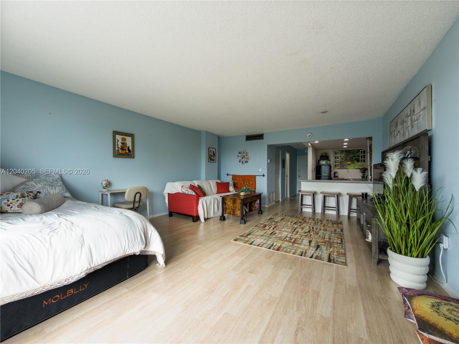 A studio apartment features a bed, a living area with a sofa, and a kitchen — 12500 NE 15th Ave # 312, North Miami FL 33161, NORTH MIAMI, FL
