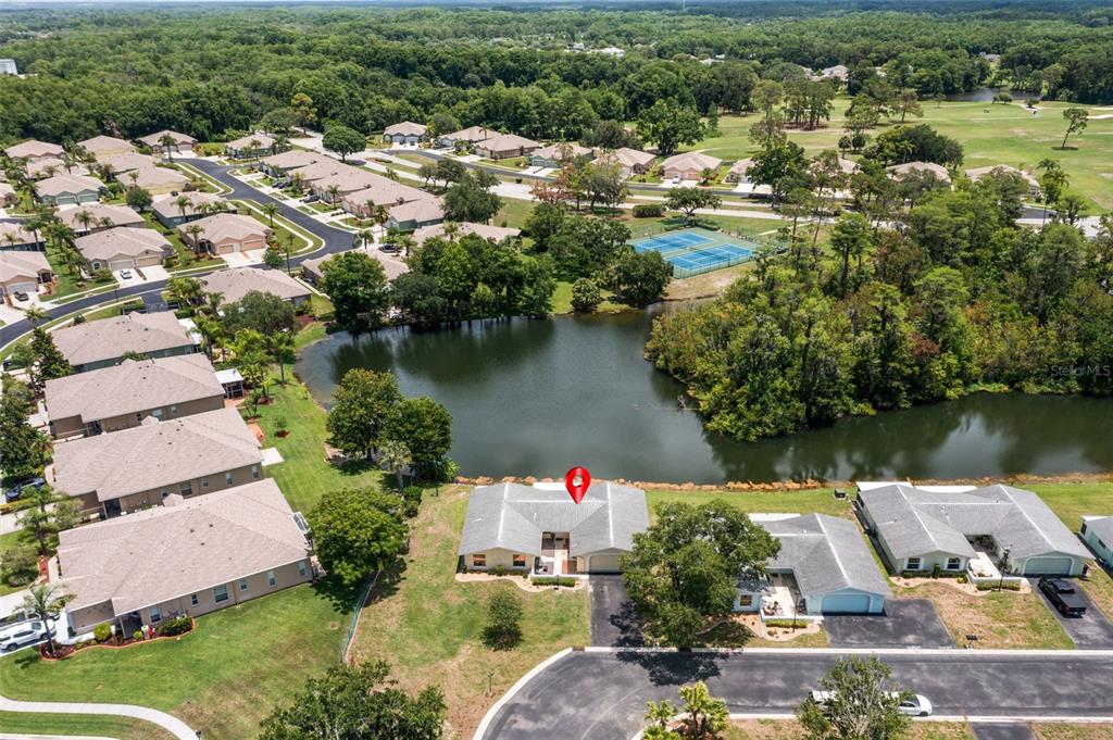 An aerial view shows a residential house with a red pin overlooking a small lake — 12102 BOYNTON LANE UNIT B, NEW PORT RICHEY, FL
