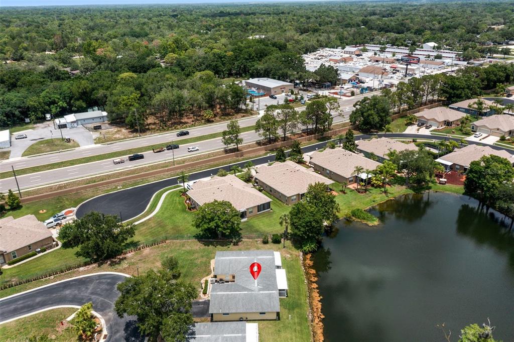 An aerial view shows a residential house with a red location pin near a lake — 12102 BOYNTON LANE UNIT B, NEW PORT RICHEY, FL